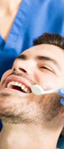 mid-adult-patient-receiving-dental-treatment-with-tools-from-female-dentist-clinic-min-min